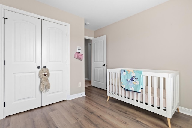 bedroom with a closet, baseboards, and wood finished floors