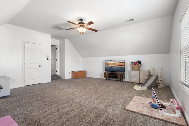 interior space featuring a ceiling fan, visible vents, vaulted ceiling, and carpet flooring