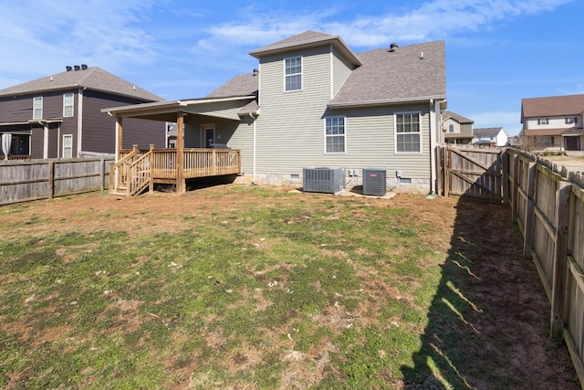 rear view of house with a deck, cooling unit, a fenced backyard, crawl space, and a lawn