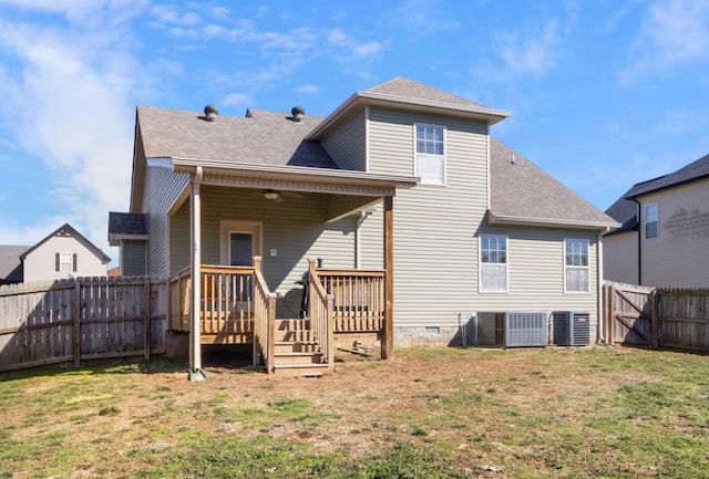 back of house with a yard, crawl space, a fenced backyard, and roof with shingles