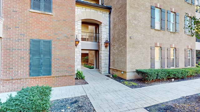 view of exterior entry featuring brick siding and stucco siding