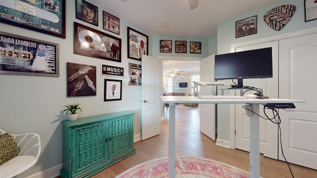 interior space featuring light wood-style flooring, baseboards, and ceiling fan