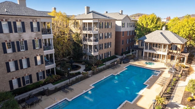 community pool with fence and a patio