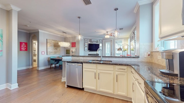 kitchen featuring dishwasher, open floor plan, cream cabinets, pendant lighting, and a sink