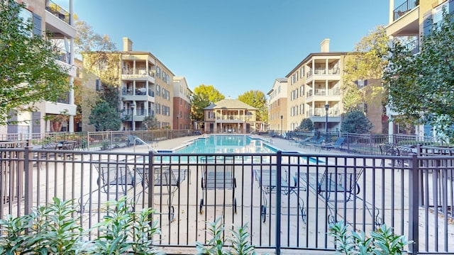 community pool featuring fence and a patio