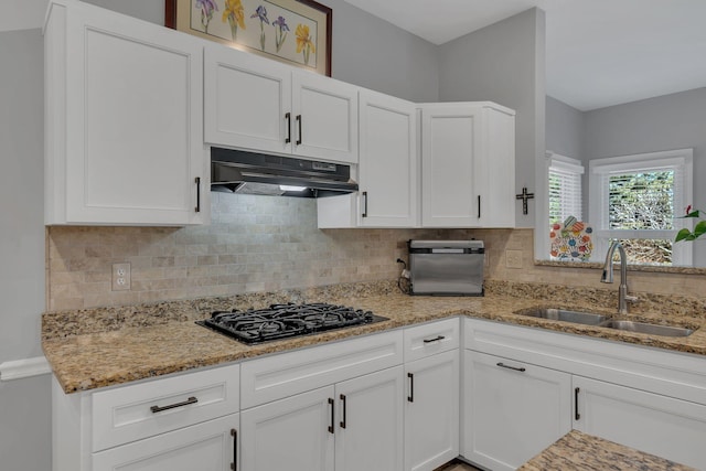 kitchen with black gas cooktop, a sink, white cabinets, and under cabinet range hood