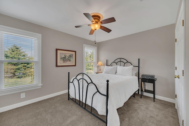 bedroom with light carpet, ceiling fan, and baseboards