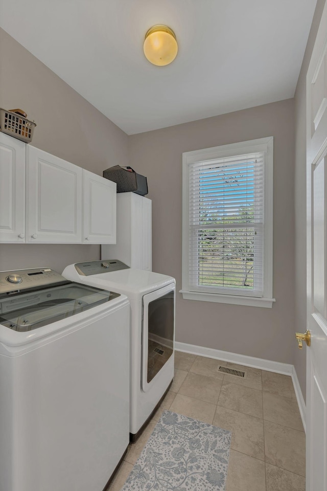 clothes washing area featuring cabinet space, baseboards, visible vents, and washer and clothes dryer