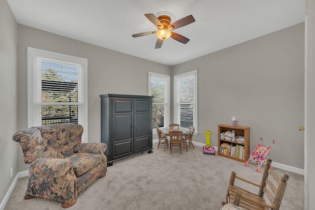 interior space featuring baseboards, ceiling fan, a healthy amount of sunlight, and light colored carpet