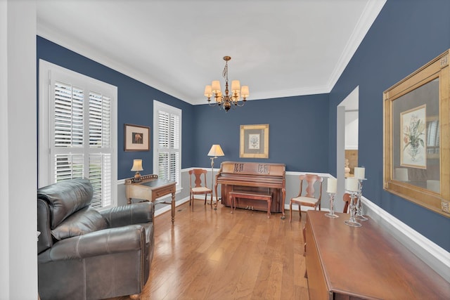 living area featuring baseboards, an inviting chandelier, light wood-style flooring, and crown molding