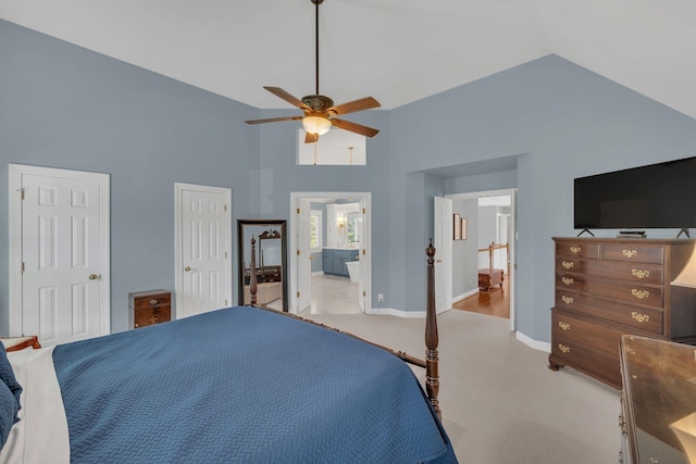 bedroom featuring high vaulted ceiling, light colored carpet, a ceiling fan, baseboards, and ensuite bath