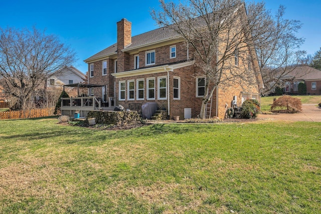 rear view of house featuring a lawn, a chimney, fence, a pergola, and brick siding