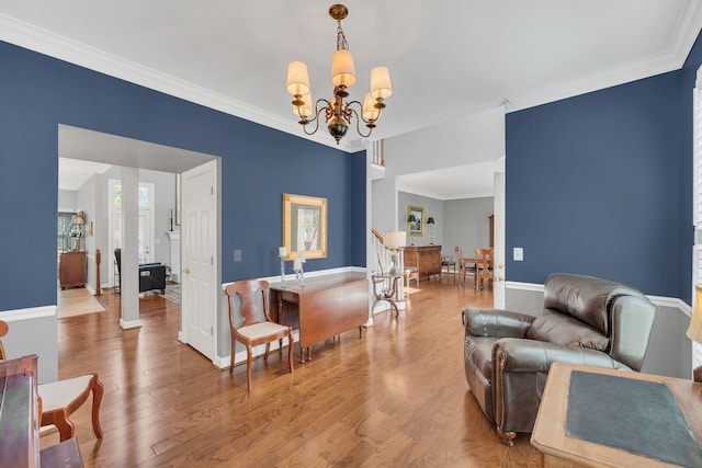 living area featuring ornamental molding, baseboards, an inviting chandelier, and wood finished floors