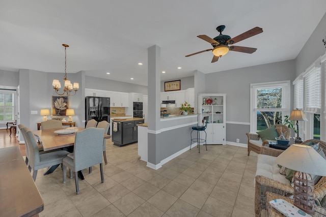 dining area with light tile patterned floors, recessed lighting, baseboards, and ceiling fan with notable chandelier