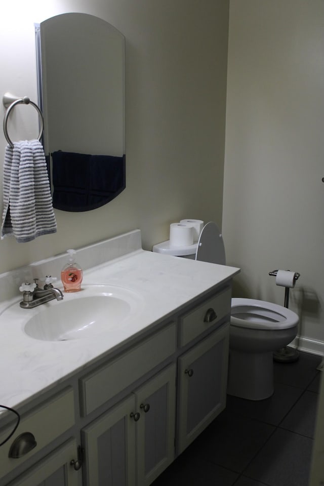 bathroom with baseboards, vanity, toilet, and tile patterned floors