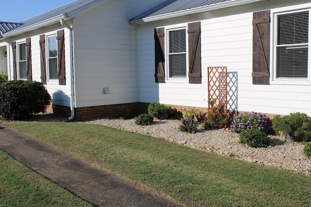 view of home's exterior featuring metal roof and a lawn