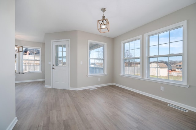 foyer entrance with a healthy amount of sunlight, visible vents, light wood-style flooring, and baseboards