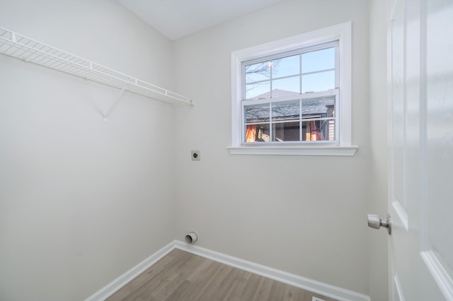 laundry room with laundry area, hookup for an electric dryer, baseboards, and wood finished floors