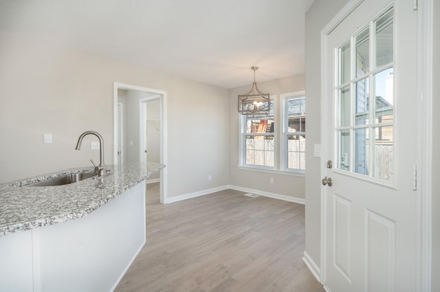 dining area featuring a chandelier, light wood finished floors, visible vents, and baseboards