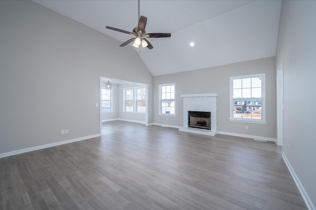 unfurnished living room featuring dark wood-style floors, plenty of natural light, a fireplace, and baseboards