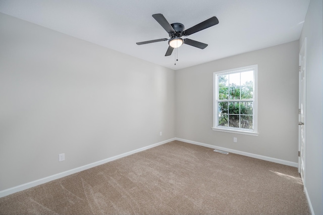 unfurnished room featuring a ceiling fan, light carpet, visible vents, and baseboards