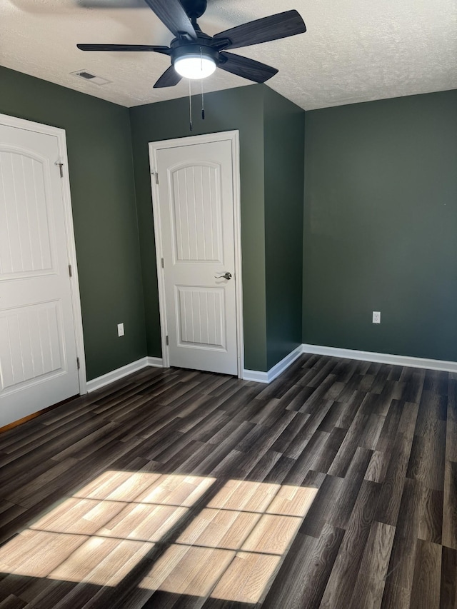 unfurnished bedroom featuring wood finished floors, visible vents, and baseboards