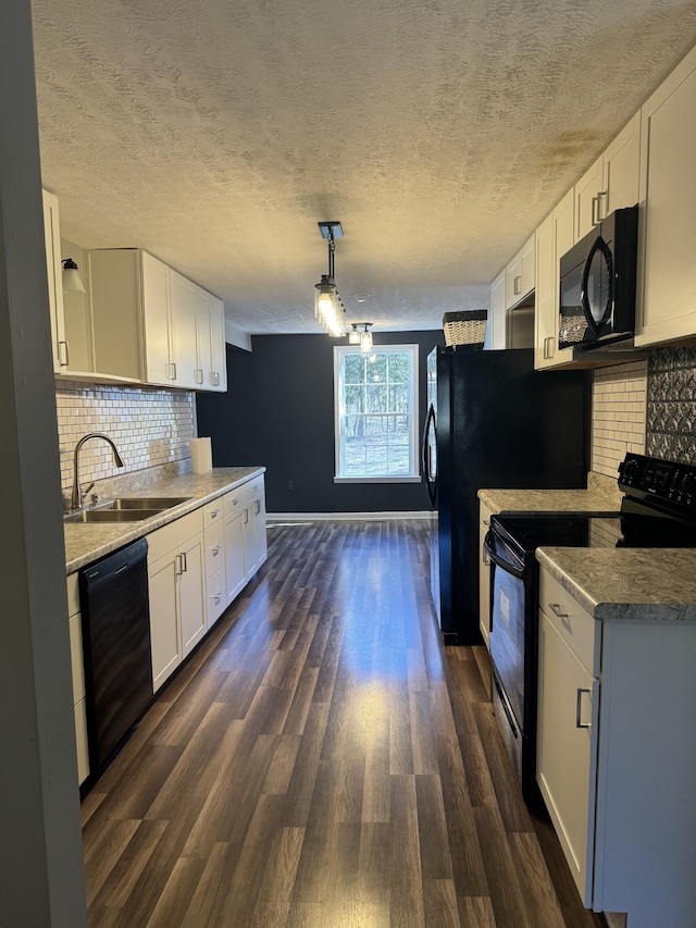 kitchen featuring a sink, black appliances, dark wood-style flooring, and white cabinetry