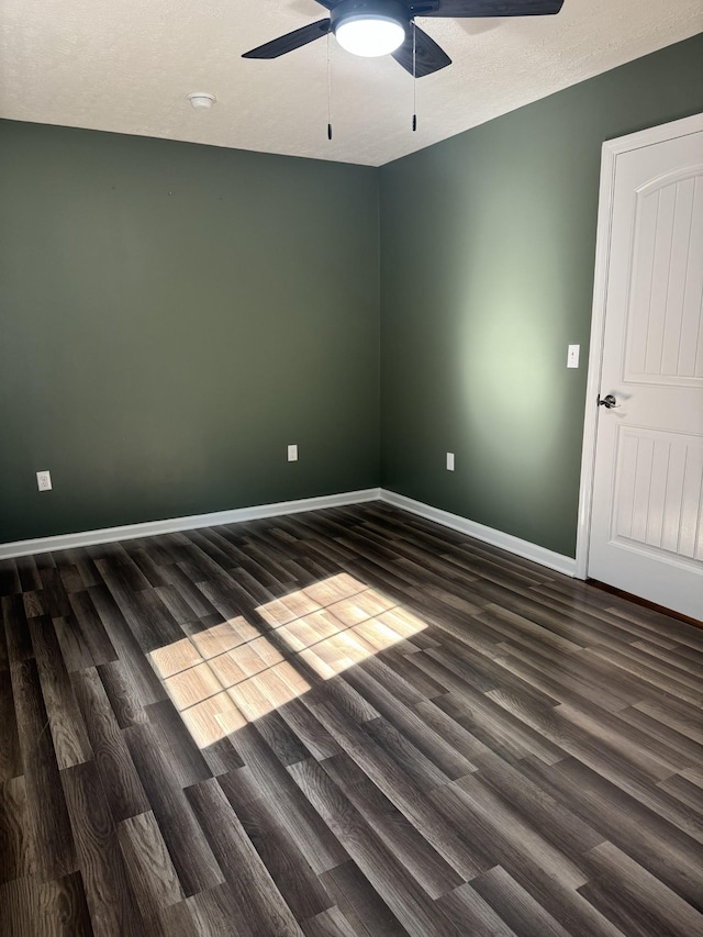 empty room with a textured ceiling, baseboards, a ceiling fan, and wood finished floors