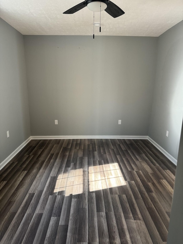 spare room with dark wood-type flooring, a ceiling fan, and a textured ceiling