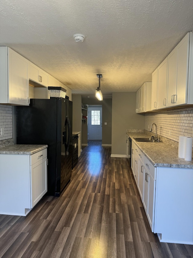 kitchen with white cabinets, black appliances, dark wood-type flooring, and a sink