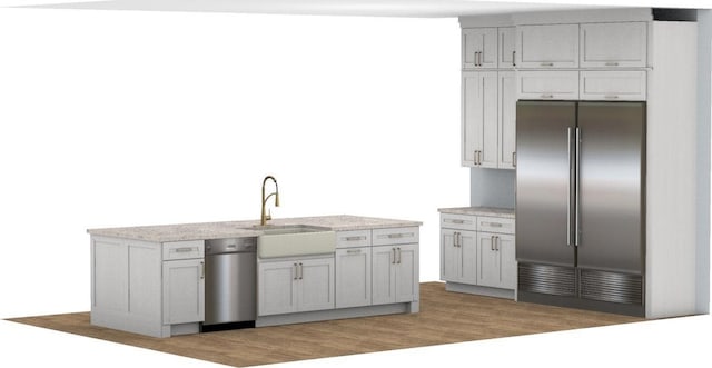 kitchen featuring high quality fridge, light countertops, a sink, and wood finished floors