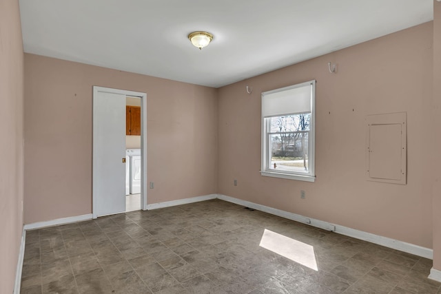 empty room featuring washer / clothes dryer, electric panel, and baseboards