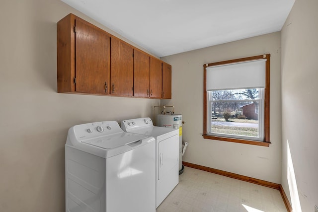 clothes washing area featuring washer and clothes dryer, light floors, water heater, cabinet space, and baseboards