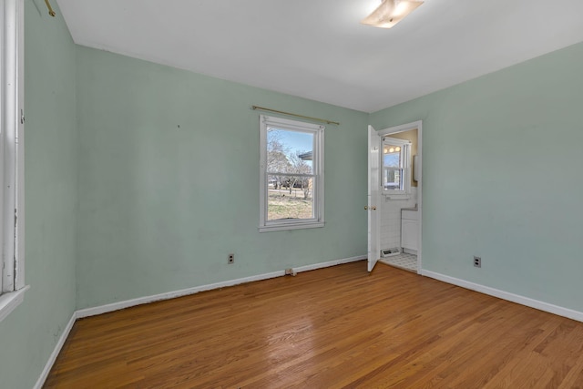 spare room featuring light wood finished floors and baseboards