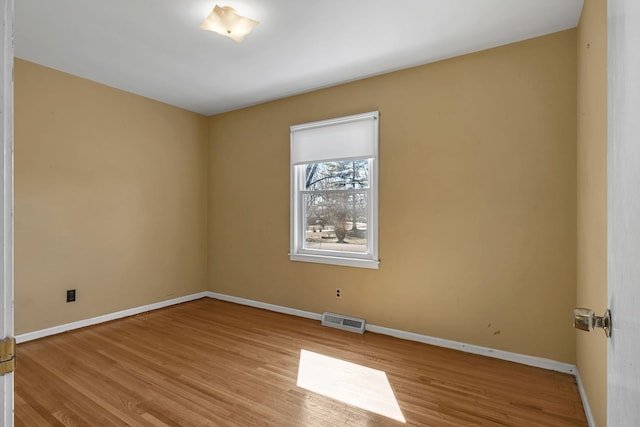 unfurnished room featuring light wood finished floors, baseboards, and visible vents