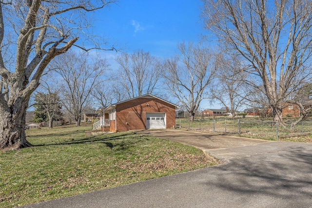 exterior space featuring driveway, an attached garage, and fence