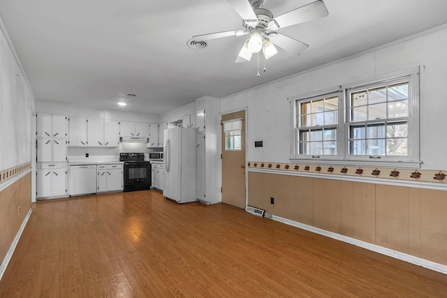 kitchen featuring white appliances, visible vents, white cabinets, light wood-type flooring, and under cabinet range hood