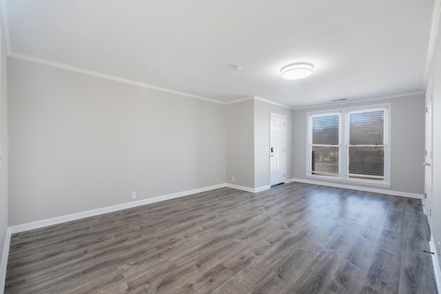 unfurnished room featuring baseboards, dark wood finished floors, and crown molding