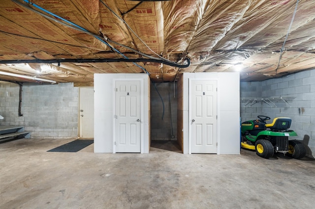 unfinished basement featuring concrete block wall