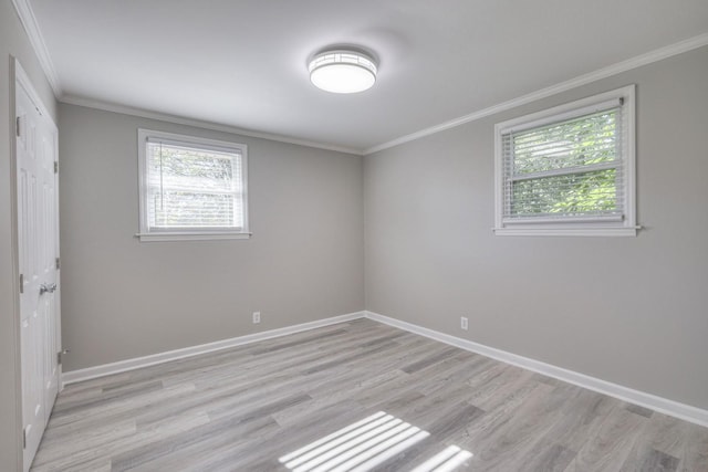 unfurnished room featuring ornamental molding, a wealth of natural light, and light wood finished floors