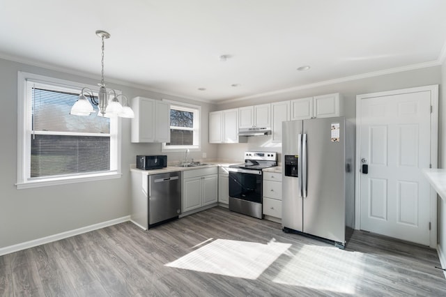 kitchen with stainless steel appliances, light countertops, under cabinet range hood, and white cabinetry