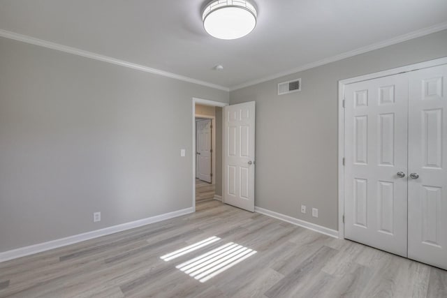 unfurnished bedroom featuring visible vents, crown molding, light wood finished floors, and baseboards