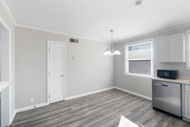 unfurnished dining area featuring visible vents, crown molding, baseboards, and wood finished floors