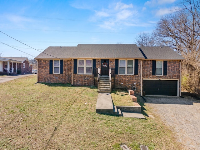 ranch-style house with a garage, brick siding, a front lawn, and gravel driveway