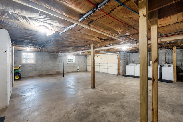 basement with a garage, visible vents, and washer and clothes dryer