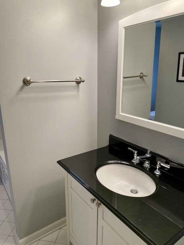 bathroom with vanity, baseboards, and tile patterned floors