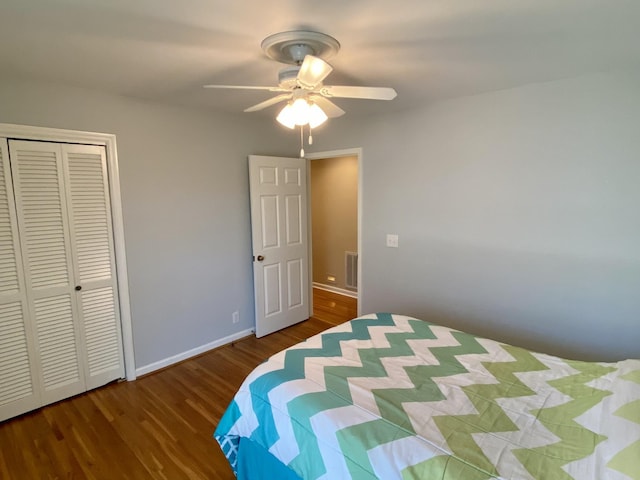 bedroom with a closet, visible vents, dark wood-type flooring, ceiling fan, and baseboards