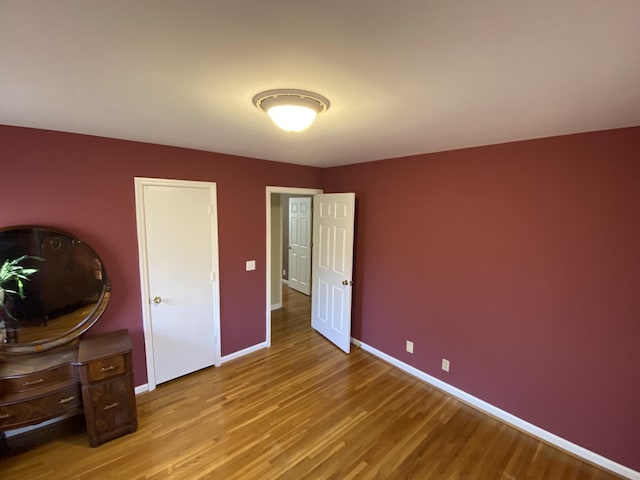 unfurnished bedroom featuring baseboards and wood finished floors