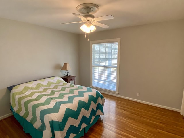 bedroom featuring ceiling fan, baseboards, and wood finished floors