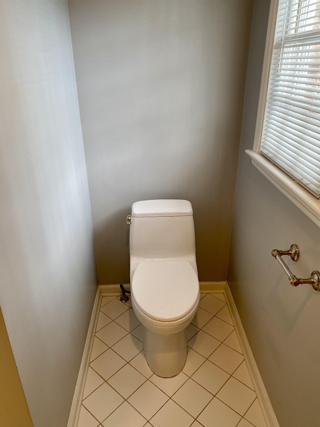 bathroom with toilet, tile patterned flooring, and baseboards